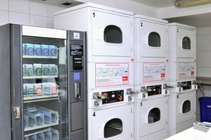 A laundry facility with multiple washing machines and a coin-operated dryer. - 18th-Floor Studio with Private Terrace & Andes Views in Providencia (Providencia)