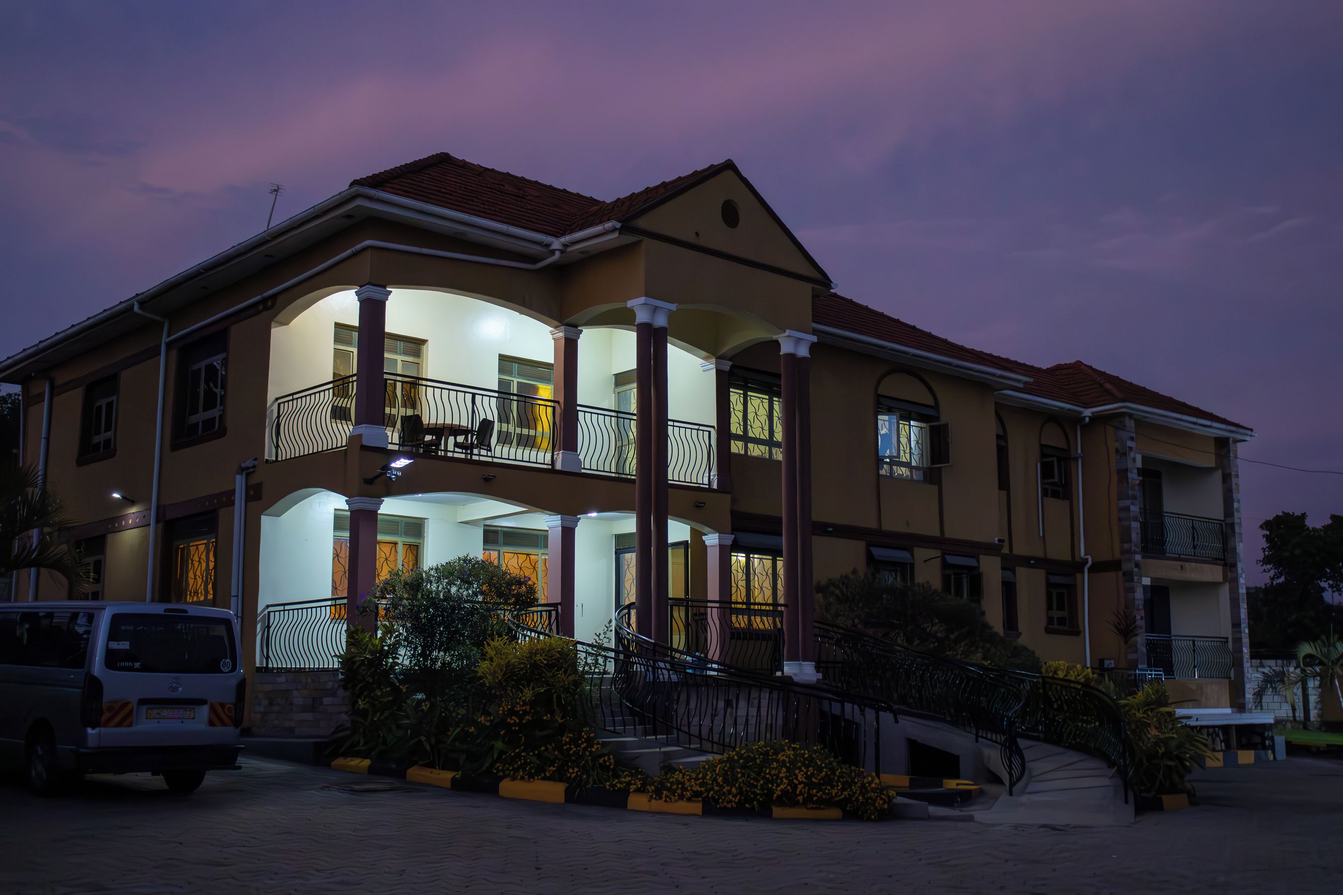 A two-story building with a balcony and a covered entrance area.