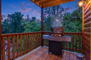 An outdoor grill on a wooden deck with a view of trees and a house in the background. - Sleeps 12, Private Indoor Pool, Hot Tub, Theater, Arcade, 6 Mi to Dollywood (Pigeon Forge)