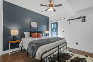 A bedroom with a bed, bedside tables, a ceiling fan, a window with curtains, and a wall-mounted shelf. - Sleeps 10, King Bed in Every Room, Hot Tub, Views, 3 Mi to Downtown Gatlinburg (Gatlinburg)