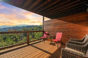 A wooden deck with a view of a forested landscape. - Sleeps 10, King Bed in Every Room, Hot Tub, Views, 3 Mi to Downtown Gatlinburg (Gatlinburg)