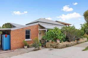 A two-story house with a brick facade, a metal roof, and a small attached garage. - Heritage Haven - A Sepal Stay (Perth)