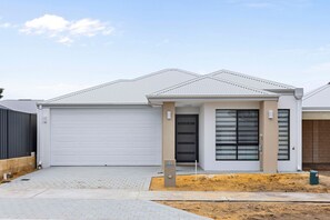 A modern two-story house with a garage, a front door, and a small porch area. - Linger Laugh - A Sepal Stay (Henley Brook)