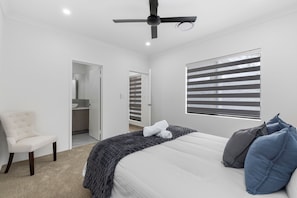 A bedroom with a bed, a chair, a ceiling fan, and a window with blinds. - Linger Laugh - A Sepal Stay (Henley Brook)