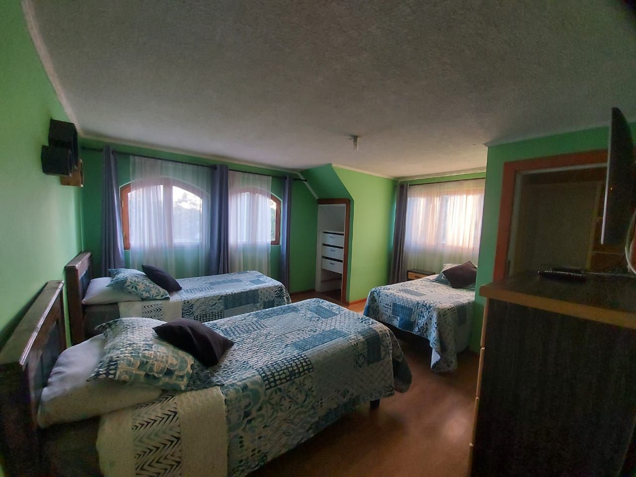 Une chambre avec deux lits, une commode et un téléviseur.