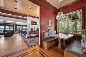 A spacious room with a wooden floor, a dining table with benches, a large window with a view, and a ceiling with wooden beams. - The April Inn - A Historic Victorian Lakehouse (Spring Grove)