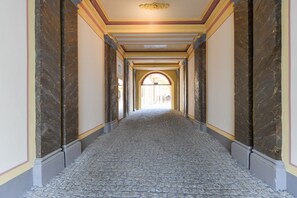 A corridor with marble walls and a patterned floor, leading to an open area. - Elegant Prague Apt•Wenceslas Square• City Center (Praha)
