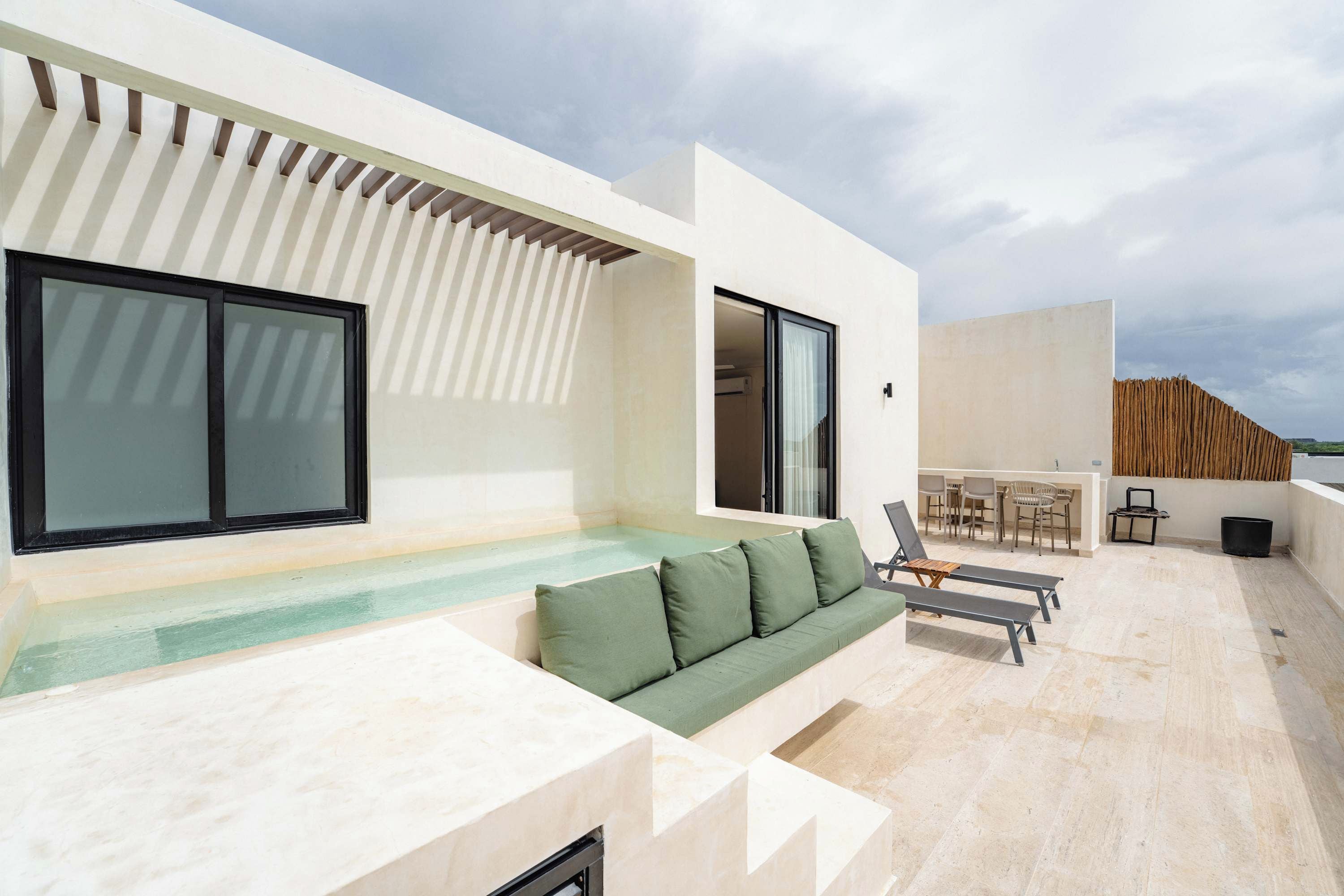 A modern outdoor terrace with a pool, seating area, and a dining space.
