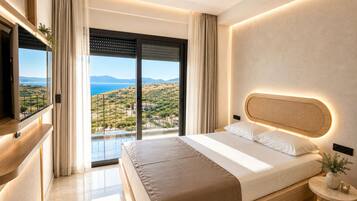 A modern bedroom with a large bed, a television, and a balcony with a view of the landscape.