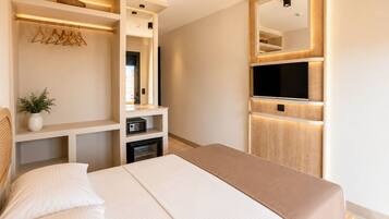 A modern bedroom with a bed, built-in TV, and a mirror.