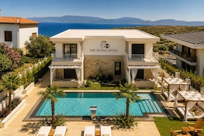 Hotel Egéria con piscina, zona de estar exterior y vistas al mar.