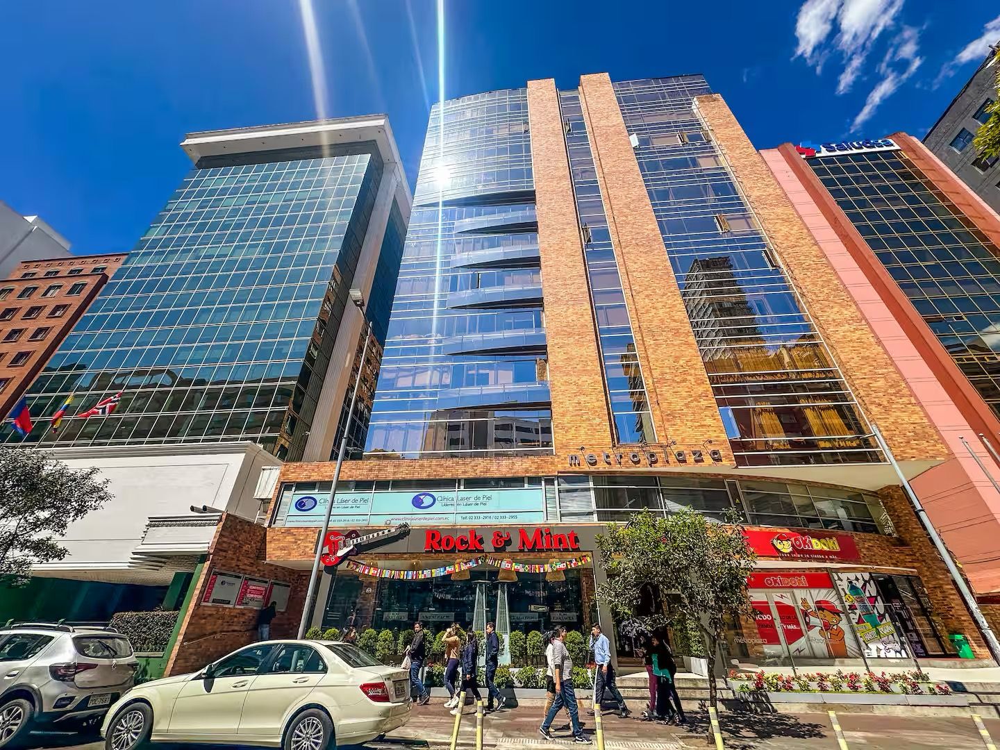 A multi-story building with a glass facade and a brick section.