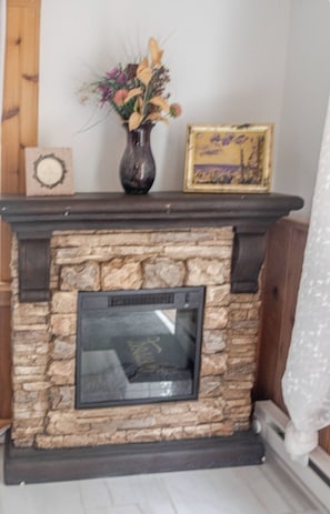 Una chimenea de piedra con un cuadro enmarcado encima.