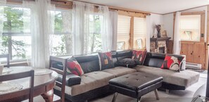 A living room with a sectional sofa, a round table, and a fireplace.