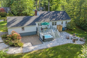 Une maison à deux étages dotée d’un patio, d’un jacuzzi et d’un espace salon extérieur.