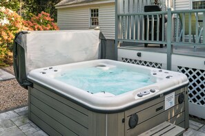 A hot tub with a cover, a control panel, and a warning label. - A Wave From It All with Hot tub (Kennebunk)