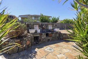 A stone patio with a water feature and planters. - 5 BRD| sleeps 10| near airport|Perth CBD| Kings Park| mint (Dianella)