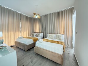 Une chambre d’hôtel avec deux lits, un ventilateur de plafond et une table de chevet avec une lampe.