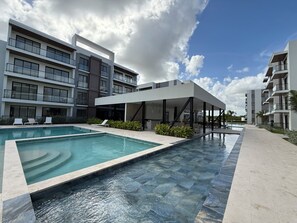 Un hôtel moderne doté d’une piscine, d’un espace extérieur aménagé et d’un patio couvert.