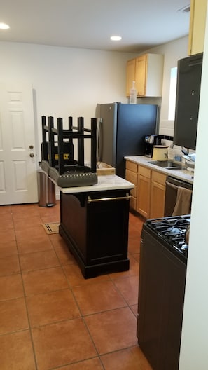 A kitchen with a stove, sink, and cabinets. - Historic Greystone 2BR/2BA near Blue Line, Laundry (Chicago)
