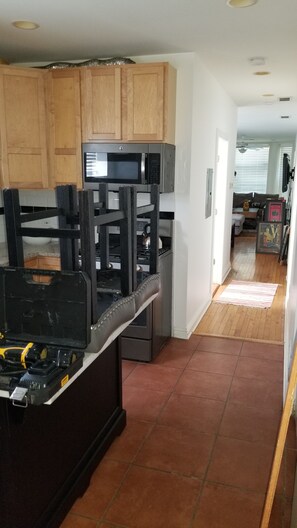 A kitchen with wooden cabinets, a microwave, and a stove. - Historic Greystone 2BR/2BA near Blue Line, Laundry (Chicago)