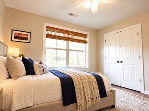 A bedroom with a bed, a window with blinds, a door, and a ceiling fan. - Peaceful 4-bedroom house in the Lakes subdivision (Oxford)