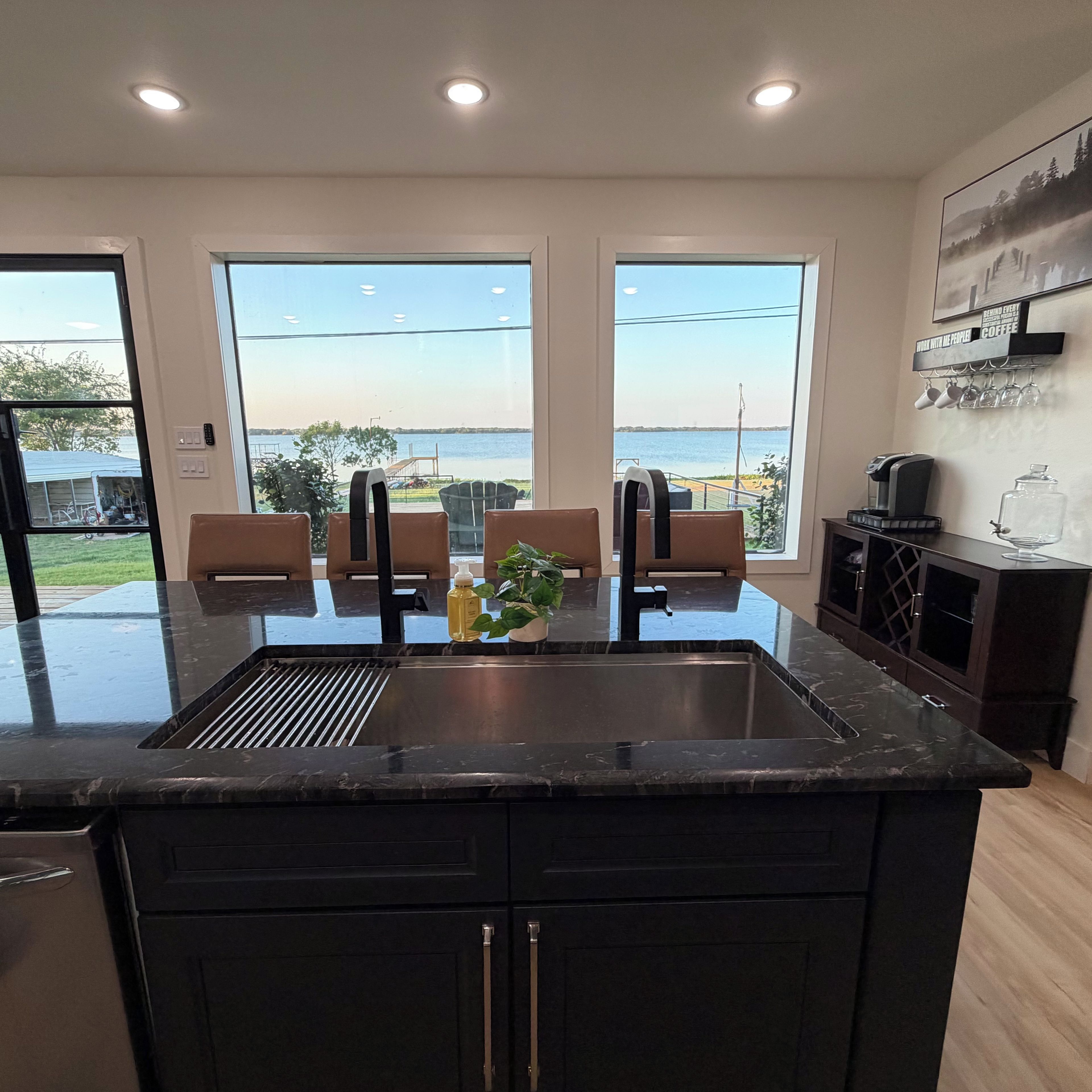 Una cocina moderna con una isla grande, un lavaplatos empotrado y vistas al agua.