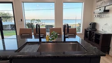 Una cocina moderna con una isla grande, un lavaplatos empotrado y vistas al agua.
