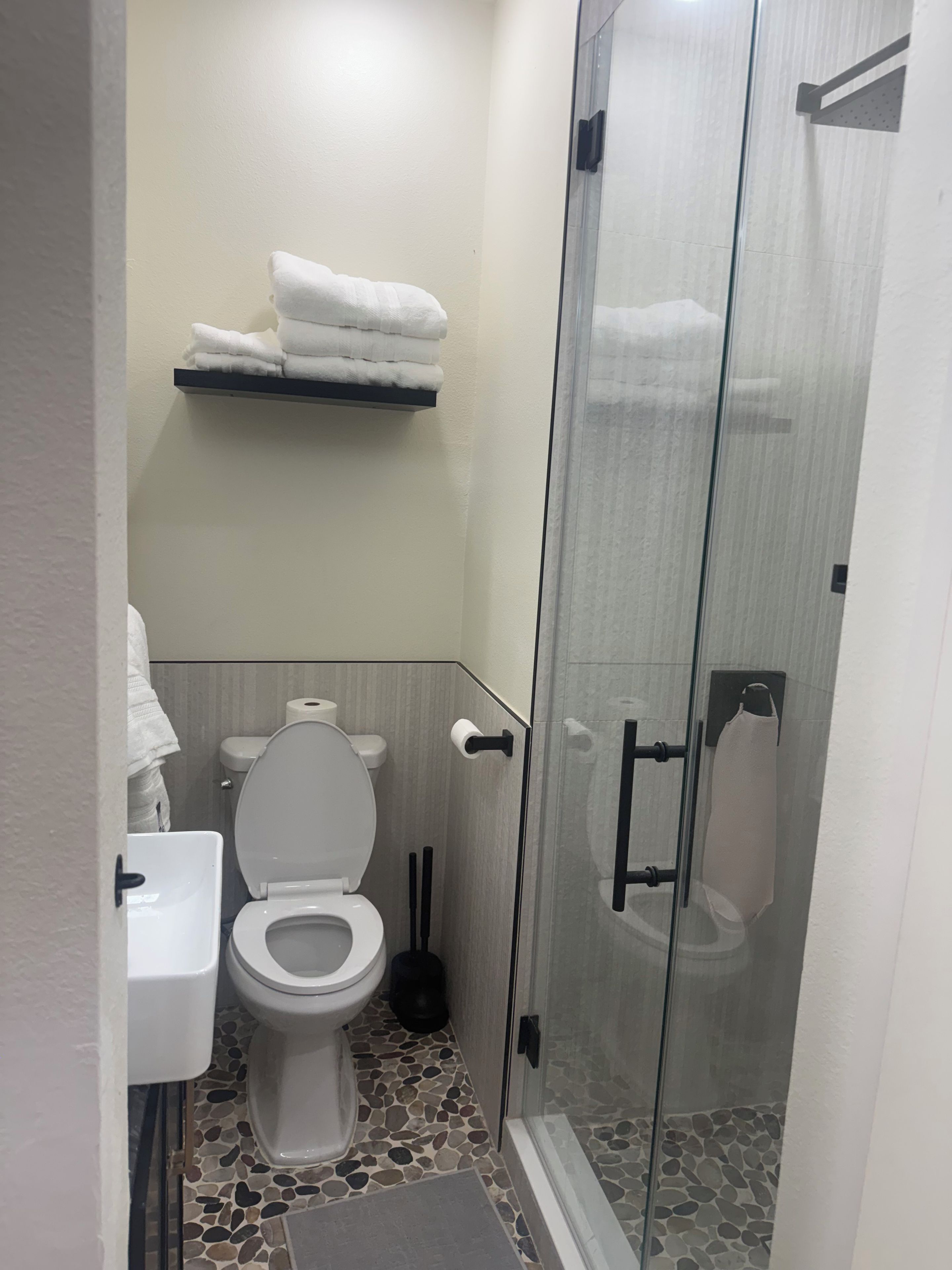 Ein modernes Badezimmer mit Toilette, Waschbecken und einer Duschkabine.