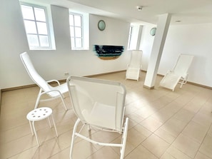 A room with white chairs, a tiled floor, and a painting on the wall. - "castle by the Sea" - Apt. 02 (Wyk auf Foehr)