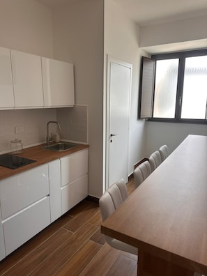A modern kitchen with white cabinets, a wooden countertop, and a built-in sink. - DAL CONSOLE (Catania)