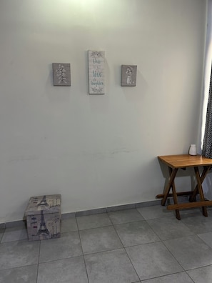 A room with a tiled floor, a wooden table, and three framed signs on the wall. - Cozy 2-bedroom apartment in fantastic Santa Ana  El Salvador with AC (Santa Ana)