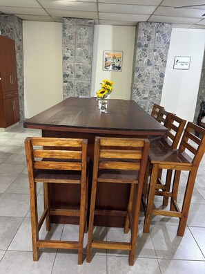 A dining area with a large wooden table surrounded by six wooden chairs. - Cozy 2-bedroom apartment in fantastic Santa Ana  El Salvador with AC (Santa Ana)