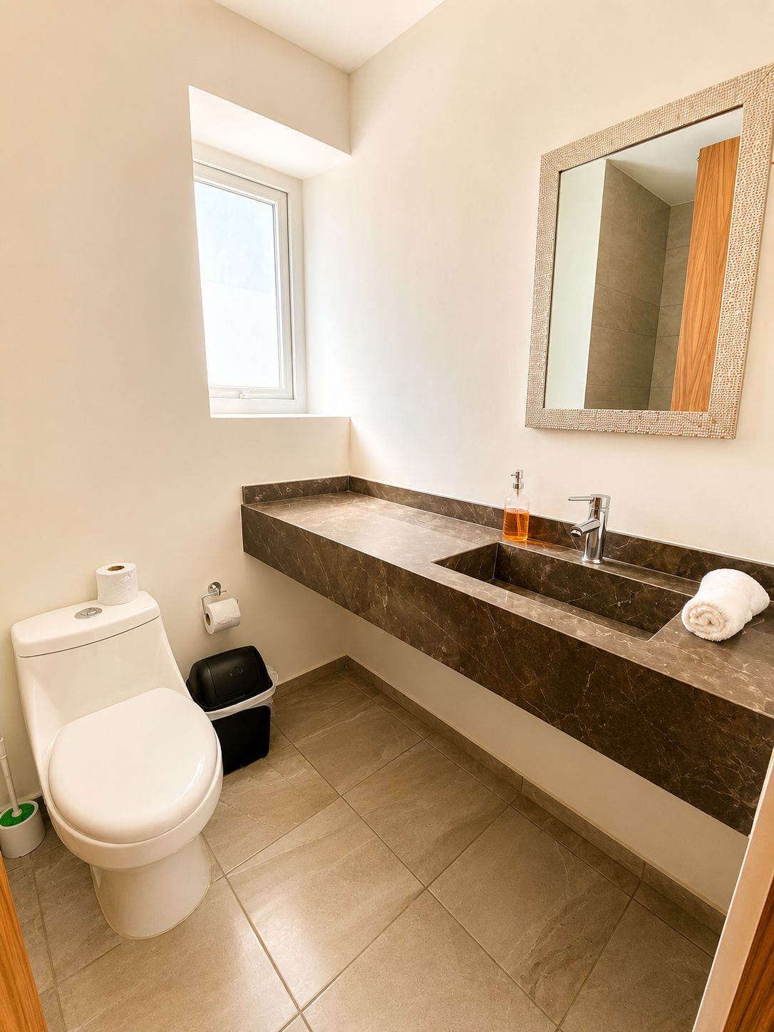 A bathroom with a toilet, sink, and mirror.