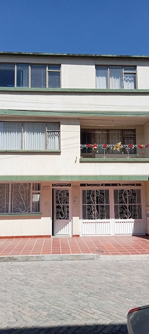 A two-story building with a balcony on the upper floor, featuring a metal railing and decorative elements. - Casa Tundama  (Duitama)