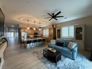 A modern kitchen with a central island, bar stools, pendant lighting, and a ceiling fan. - Winter Snowbird Retreat in Lake Havasu City, Arizona! Brand New Island Home (Lake Havasu City)