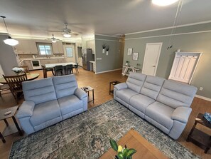 Ein geräumiges Wohnzimmer mit zwei Sofas, einem Couchtisch und einem Teppich.