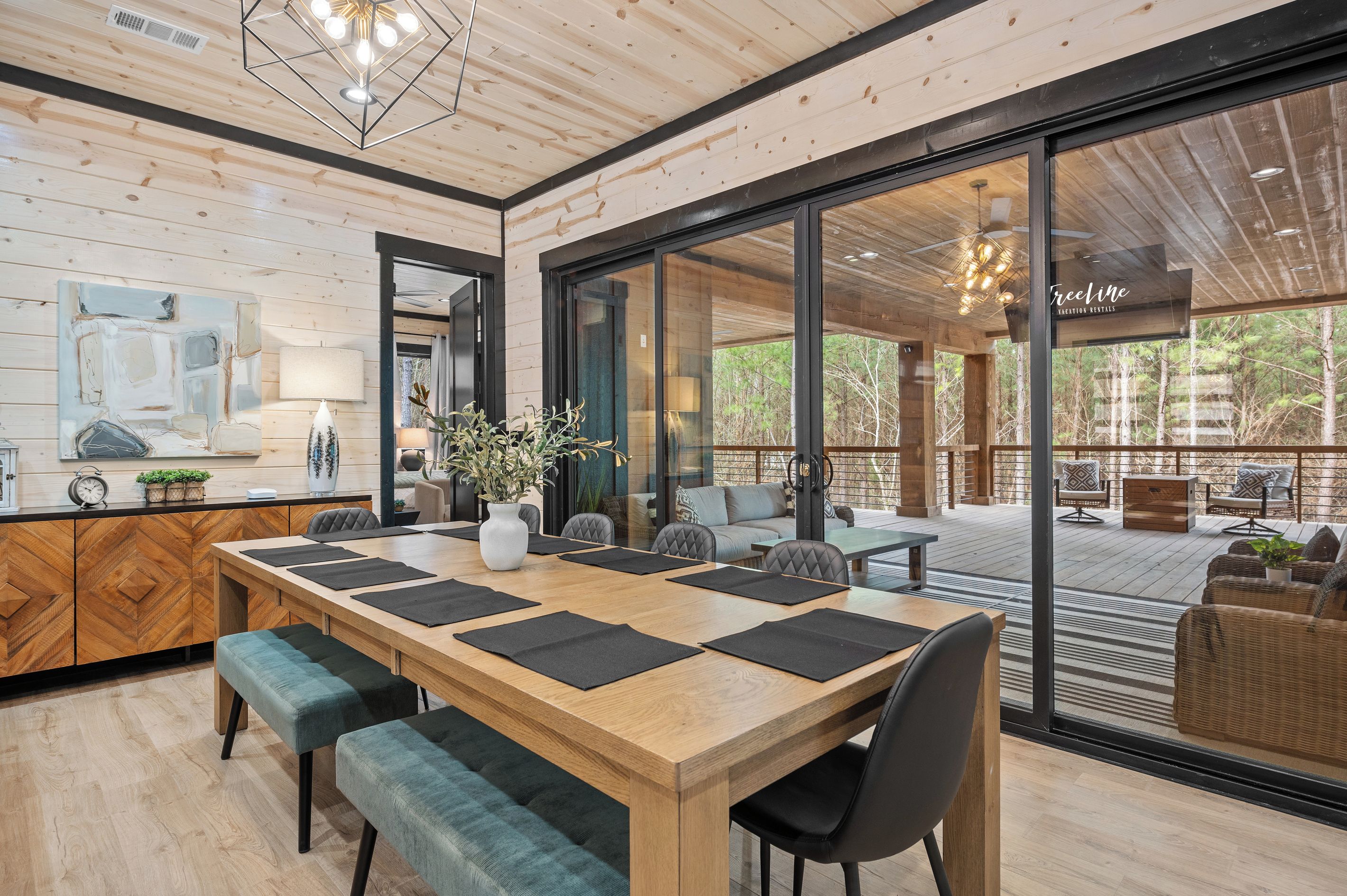 A spacious room with a large wooden dining table, comfortable seating, and a view of the outdoors.