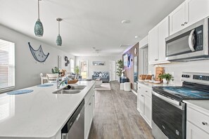 A modern kitchen with white cabinetry, a built-in oven, and a microwave. - The Best Stay 420 - Cozy 4BR Home Near Savannah (Port Wentworth)