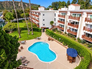 A hotel with a swimming pool, outdoor seating, and a view of a hilly landscape. - Renovated Condo Near Omni La Costa Resort & Golf! (Carlsbad)