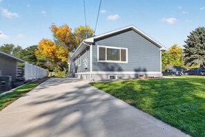 Une maison d’habitation de plain-pied avec un jardin devant, une allée et une vue sur la rue.