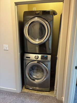 A compact, wall-mounted washer and dryer unit in a hallway. - Nice 2-bedroom townhome with AC in pleasant Portland (Portland)