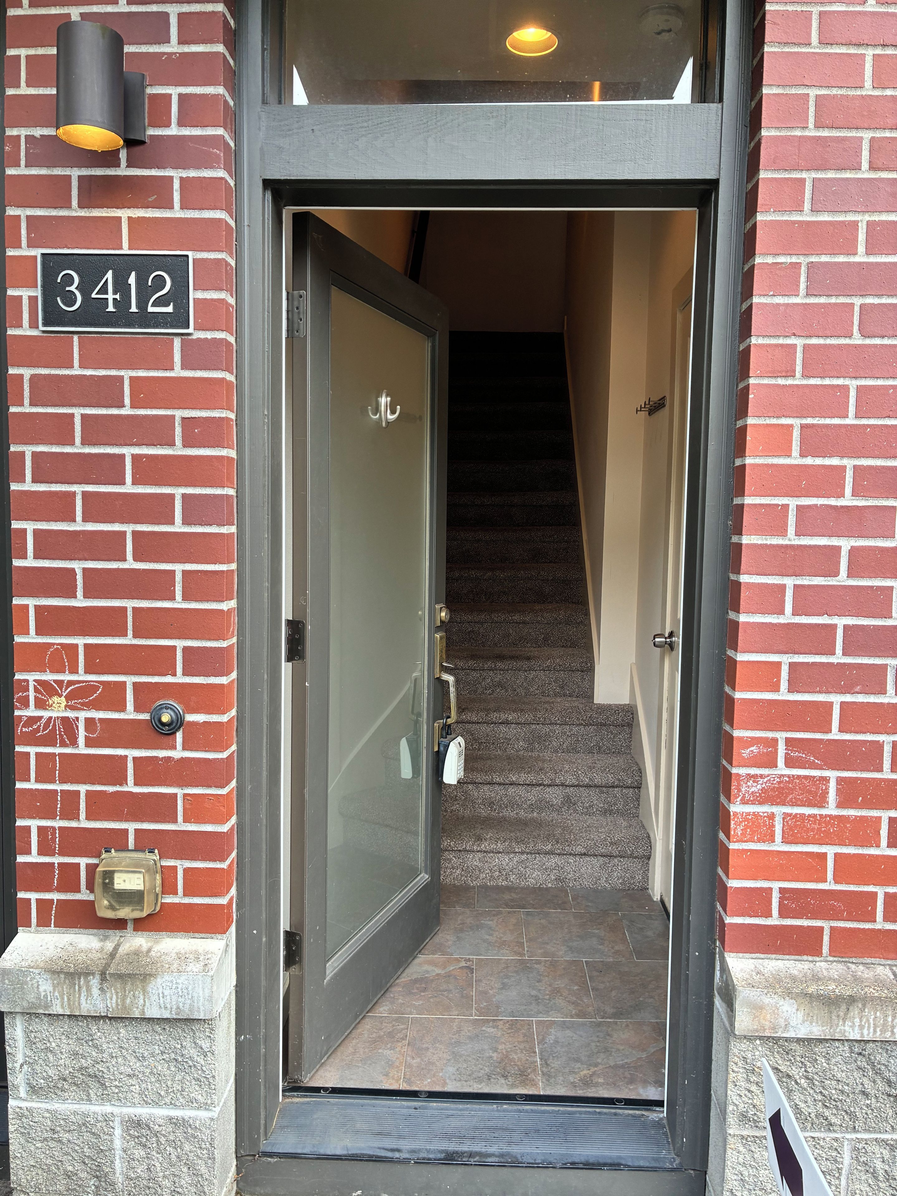 Une porte portant le numéro « 3412 » et un escalier menant à l’intérieur.