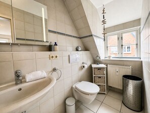 A bathroom with a sink, toilet, and window. - "living in the Countryside", HT 6 (Oldsum)