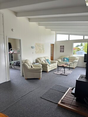 Ein Wohnzimmer mit einem Etagenbett, zwei Sofas, einem Couchtisch und einem Fernseher.