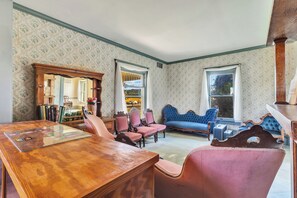 Ein Zimmer mit einem Holztisch, Stühlen, einem blauen Sofa und einem Bücherregal.
