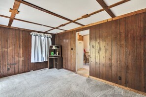 Ein Zimmer mit Holzwänden, einer weißen Decke und einem Teppichboden.