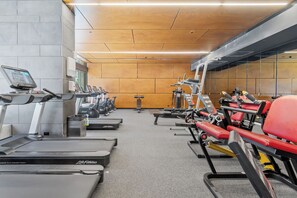 A gym with treadmills, weight machines, and a mirrored wall. - Top Floor City Escape | 180° Views, Pool, Parking (Melbourne)