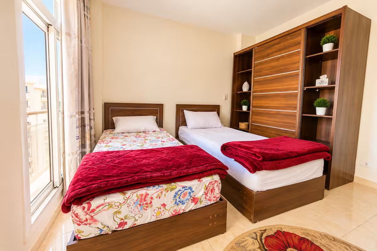 Una camera da letto con due letti, un armadio grande e una finestra.