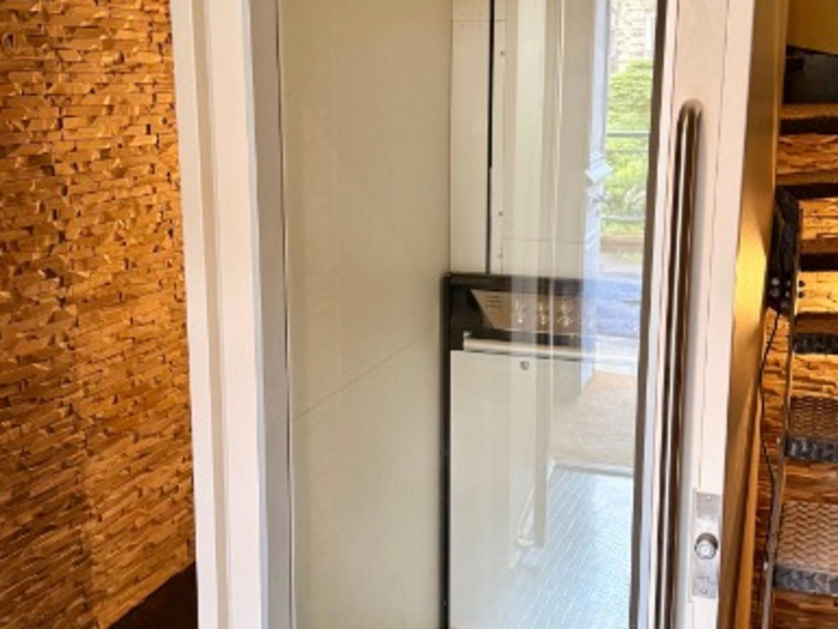 A modern kitchen with a refrigerator, a wooden wall, and a window.